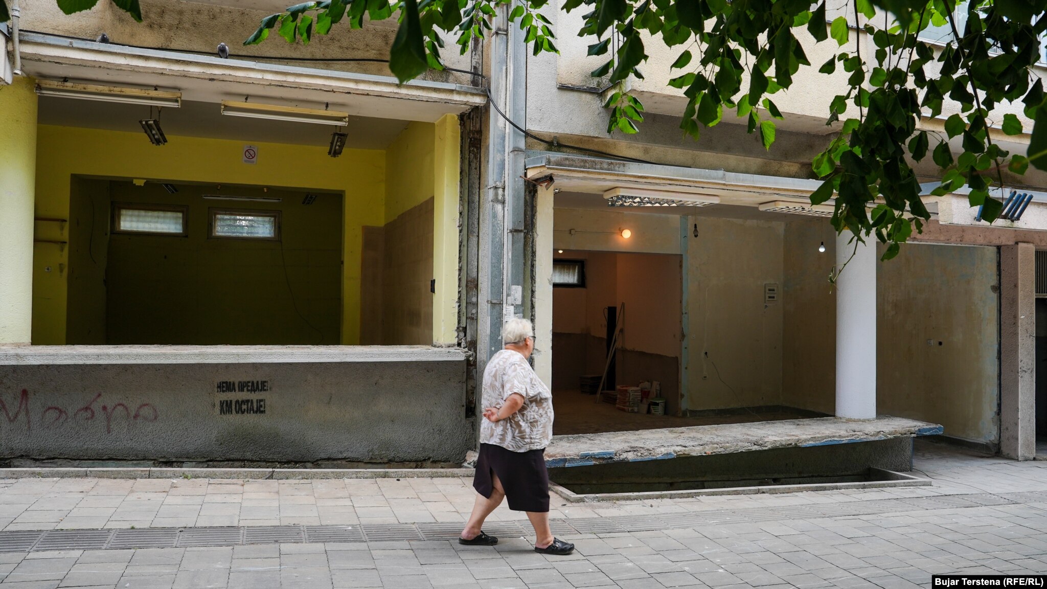 Një grua kalon pranë lokalit ku do të hapet pastiçeria "Misini" në Mitrovicë të Veriut.