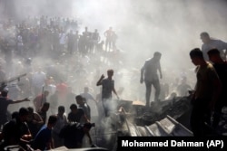 Palestinians inspect the rubble of destroyed buildings following Israeli air strikes on the town of Khan Younis in the Gaza Strip on October 26.