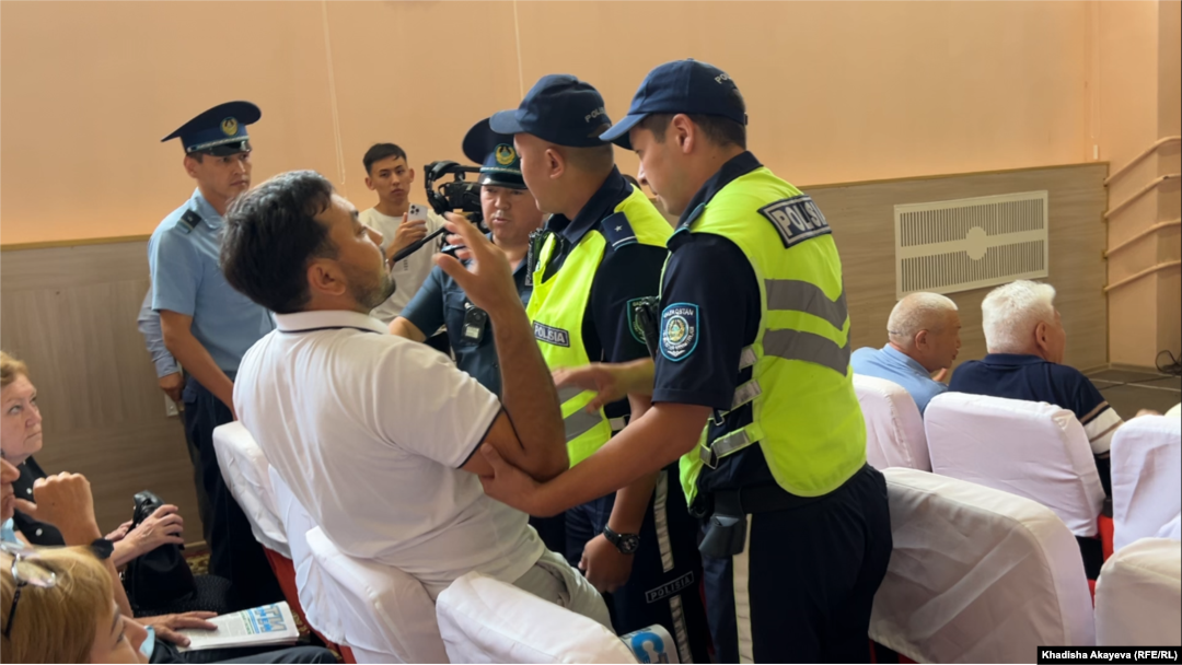 Police escort activist Eldos Dosanov out during public discussions in Semey on the construction of a nuclear power plant on August 8.