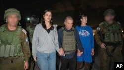 Judith Raanan, în dreapta, și fiica ei de 17 ani, Natalie, sunt escortate de soldați israelieni și de Gal Hirsch, coordonatorul special al premierului Benjamin Netanyahu pentru întoarcerea ostaticilor, vineri, 20 octombrie 2023.