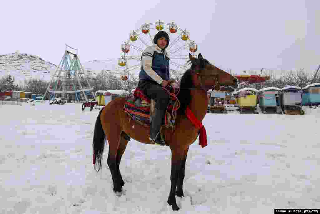 An Afghan horseman rides his animal through snow in Kabul.&nbsp;