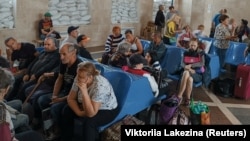 Local residents wait for an evacuation train at a railway station in Kherson on June 6.