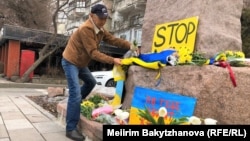 Kazakh civic activist Marat Turymbetov lays flowers on a monument to Ukrainian poet Taras Shevchenko in the Kazakh city of Almaty on February 24.