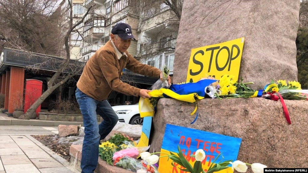 Алматинский активист Марат Турымбетов возлагает цветы и флаг Украины к памятнику Тараса Шевченко. 24 февраля 2023 года
