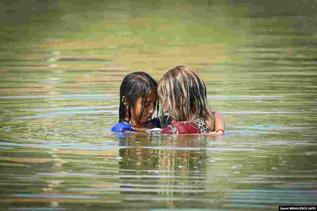 A woman and a girl swim in the water of an abandoned irrigation station in the village of Frasinet, Romania.&nbsp;