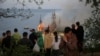 Emberek nézik a lángokban álló és a helyiek által Harry Potter-kastélynak nevezett jogi akadémiát Odesszában 2024. április 29-én