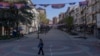 A woman walks under Serbian flags in North Mitrovica, predominantly populated by the ethnic Serb minority, amid municipal elections in the north of Kosovo on April 23.