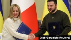 Ukrainian President Volodymyr Zelenskiy (right) and Italian Prime Minister Giorgia Meloni shake hands before a joint news briefing in Kyiv on February 21. 