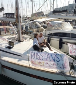 Arsenii Vesnin și iubita sa, Xenia, pe iahtul Oikumena, pe care au agățat mesajul „Ruși anti-război”.