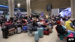 Pasageri așteptând în aeroportul Ben Gurion din Tel Aviv pe 7 octombrie, după ce mai multe curse au fost anulate din cauza atacului Hamas asupra Israelului.