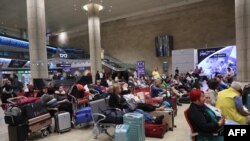 Pasagerii așteaptă la Aeroportul Ben Gurion lângă Tel Aviv, Israel, la 7 octombrie 2023, întrucât zborurile sunt anulate din cauza atacului surpriză al Hamas. 