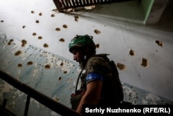 Ukrajinski vojnik se penje stepenicama izrešetanog Doma kulture u Blahodatnu, 17. juni 2023.