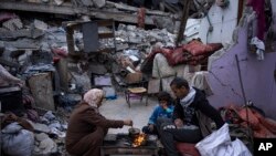 Një familje palestineze duke bërë iftar gjatë Ramazanit jashtë shtëpisë së tyre të rrënuar nga lufta, Gazë, mars 2024.