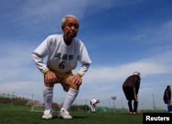 83-річний Муцухіко Номура розминається під час тренування зі своїми товаришами у футбольній команді, середній вік гравців становить 65 років. Токіо, Японія