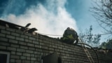 Vatrogasac poliva vodu kroz urušeni krov porodične kuće u Harkivu, 3. maj 2024.
