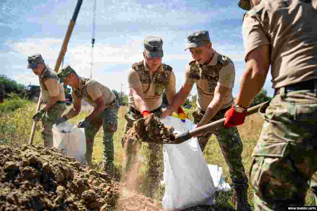 Romanian soldiers fill sand bags at the site. Bucharest has strengthened monitoring of its air space following repeated Russian missile attacks close to its border.