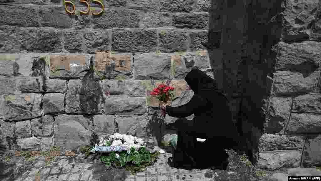 Srpska pravoslavna časna sestra polaže cveće na spomenik. &nbsp;