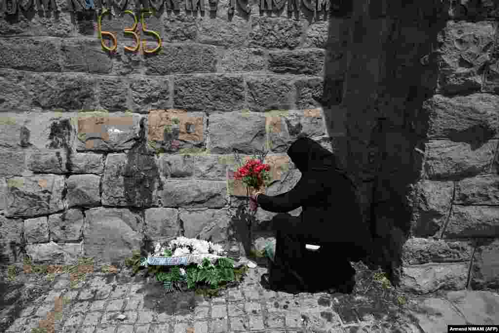 A Serb Orthodox nun lays flowers at the memorial. &nbsp;