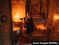 A Jerusalem Armenian woman lights candles inside the Cathedral of St. James during a service on June 14.