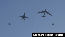 Американски Lancer (в средата вляво) и Stratofortress (в средата вдясно), ескортирани от два шведски изтребителя Gripen, прелитат над Стокхолм на 6 март. Полетът над шведската столица е част от съвместни учения между военните на САЩ и Швеция.