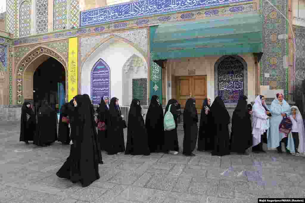 Iranke čekaju u redu za glasanje na biračkom mjestu. Sva četiri imena na glasačkom listiću provjerilo je i odobrilo Vijeća čuvara, koje nadzire izbore i zakonodavstvo.
