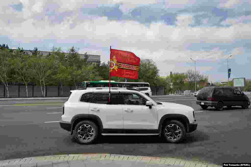 Автомобиль с флагом в честь праздника на одной из улиц Астаны