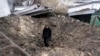 A man stands inside a shelling crater following a drone attack in Odesa, southern Ukraine, on December 14. 