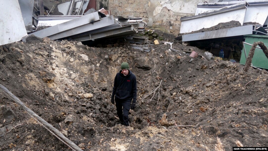 A man stands inside a shelling crater following a drone attack in Odesa, southern Ukraine, on December 14. 
