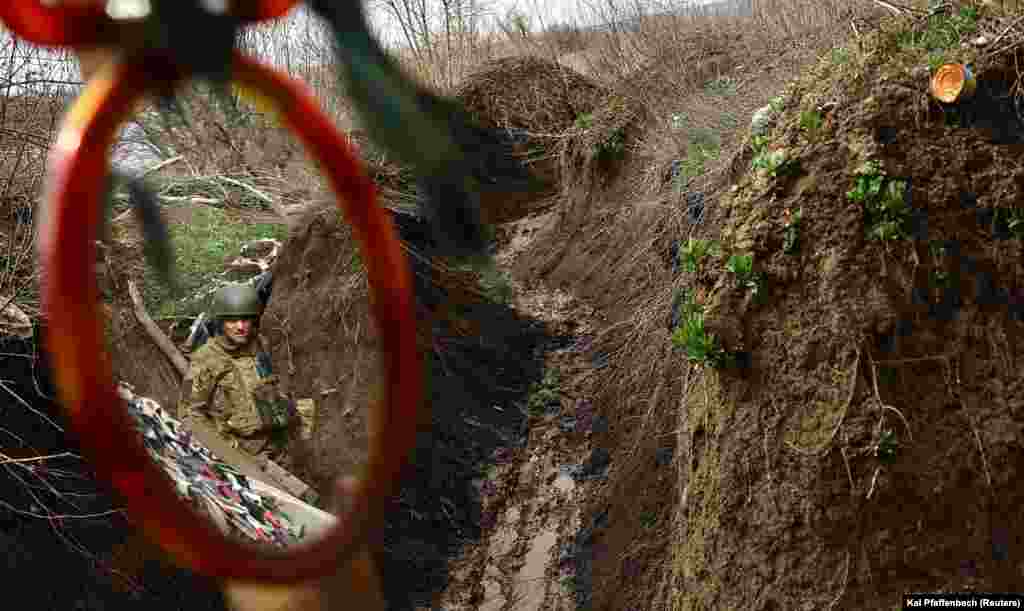 Un soldat în tranșee văzut într-o oglindă retrovizoare.