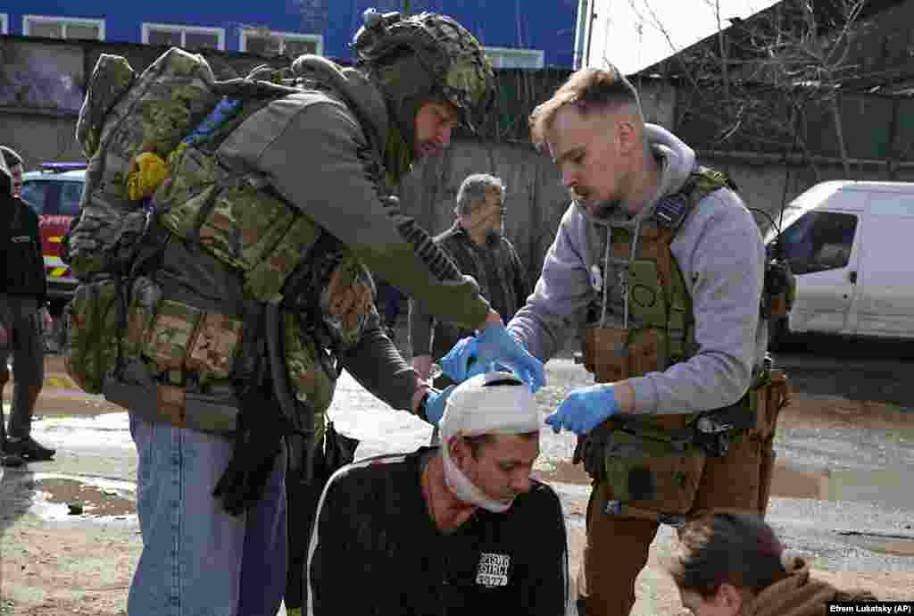 Medics apply first aid to an injured man. ​​​​​​​Oleh Synehubov, the regional governor, told national TV,&nbsp;&quot;According to preliminary data, it was a cruise missile.&quot; &nbsp;