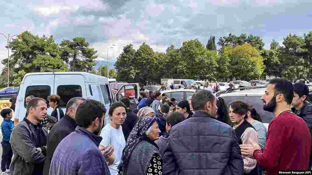 A local government worker (right) tries to calm residents after shooting was heard in Stepanakert.