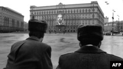 Съветски полицаи гледат портрета на Ленин на фасадата на сградата на КГБ, Москва, 7 ноември 1990 г. Това е последният път преди разпадането на СССР година по-късно, когато градът е украсен с комунистическа символика по повод годишнината от октомврийския преврат през 1917 г.
