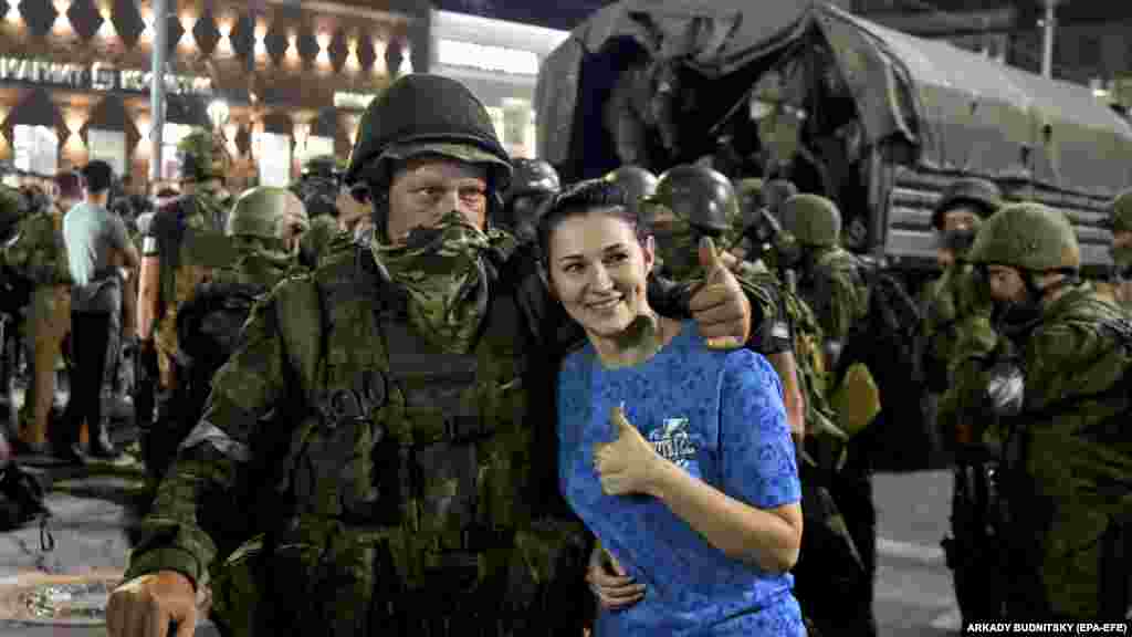 A woman poses for a photo with a Wagner member.