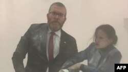 გჟეგოჟ ბრაუნმა (მარცხნივ) ცეცხლმქრობით ჩააქრო სანთლები შანდალზე, რომელიც ებრაული დღესასწაულის, ჰანუკის დროს გამოიყენება.