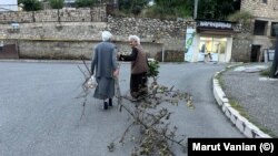 Ստեփանակերտցի երկու տարեց կանայք՝ հուլիսի 17-ի երեկոյան։ Կանանցից մեկը քարշ է տալիս ծառի ճյուղը, որով հոգալու է վառելափայտի խնդիրը։