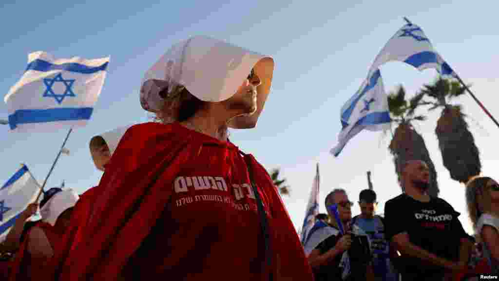 Egy, A szolgálólány meséje televíziós sorozat szereplőjének öltözött nő tüntet az izraeli igazságügyi reformok ellen az amerikai konzulátus közelében Tel-Avivban 2023. július 18-án
