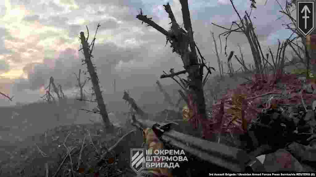 Український військовий стріляє по позиціях противника з траншеї. Фото-скріншот з відео бою навколо Андріївки на Донеччині з нашоломної камери бійця ЗСУ 3-ї окремої штурмової бригади.&nbsp;Агенція Reuters отримала фото 17 вересня 2023 року. Військові 3-ї ОШБр повідомили у фейсбуці 18 вересня, що &laquo;селище, хоч і було звільнено бійцями 3-ї ОШБр, але тепер перебуває під постійними обстрілами та спробами ворога штурмувати його&raquo;