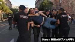 Armenian police officers detain a protester outside the government building in Yerevan on August 8. Tensions between Baku and Yerevan have escalated sharply in recent days as both sides accuse the other of cross-border gunfire and violating agreements.