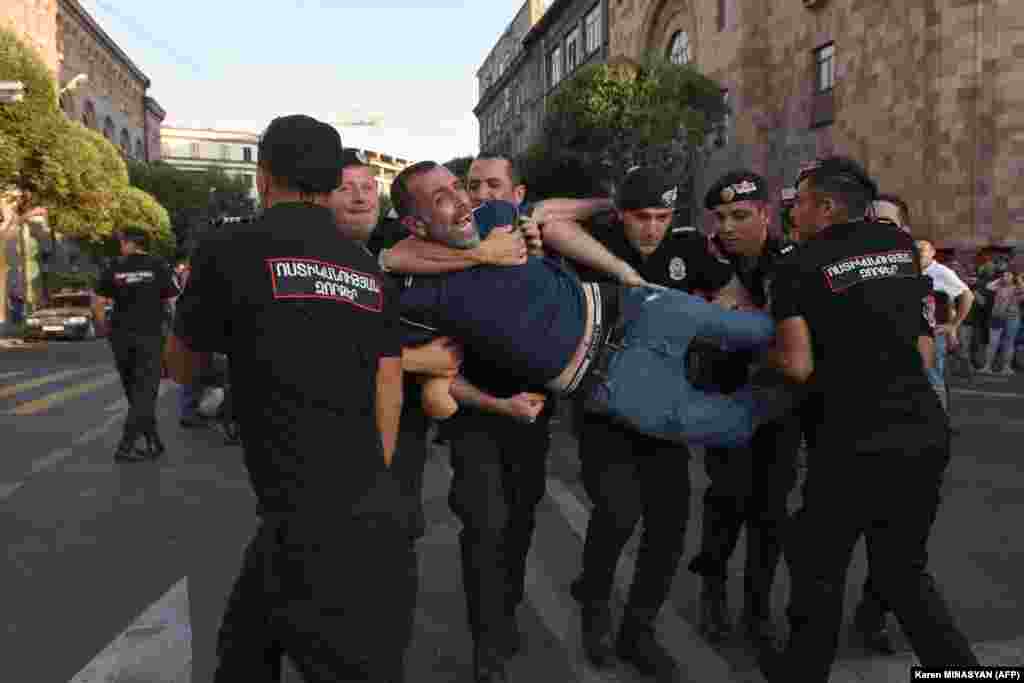 Armenian police detain a protester outside the government building in central Yerevan on August 8. Armenian police detained a dozen protesters, mostly war veterans, after they blocked a government building, demanding authorities take steps to end Azerbaijan&#39;s blockade of the Lachin Corridor. The Lachin Corridor is the sole road linking the breakaway Armenian-populated region of Nagorno-Karabakh with Armenia.
