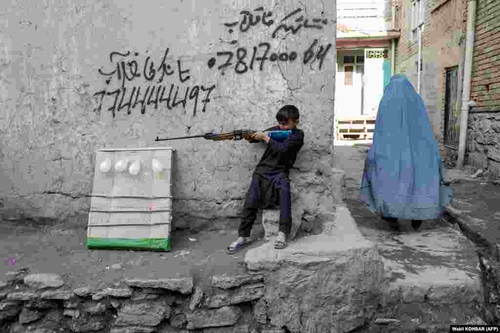 A boy plays with an air gun in Kabul.