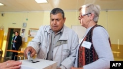 A voter casts his ballot at a polling station during the country's parliamentary elections in Sofia on October 2, 2022.