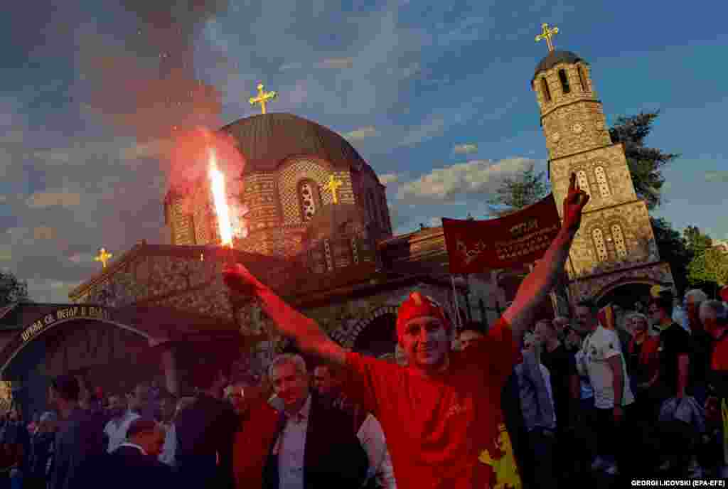 A supporter of the main opposition party, VMRO-DPMNE, holds a torch during a rally ahead of parliamentary elections and a presidential runoff in the garden of the St. Petar and Pavle Orthodox Church in Skopje, North Macedonia.
