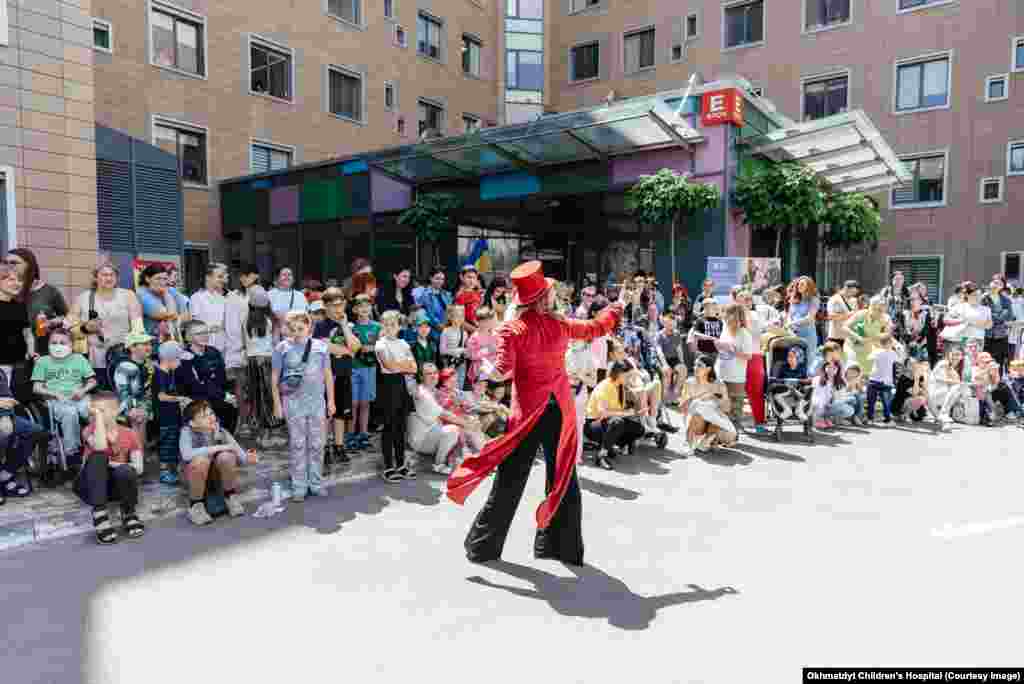 An entertainer performs for patients and families outside the main building of Kyiv&rsquo;s Okhmatdyt children&#39;s hospital on May 31. &nbsp; A day after at least 43 people -- including a staff member of and a visitor to the Okhmatdyt children&#39;s hospital -- were killed in the deadliest wave of attacks in recent months, the Kremlin on July 9 denied that it had targeted civilian targets and blamed anti-missile fire for the destruction of the hospital, but analysts and several officials rejected Moscow&#39;s denial.