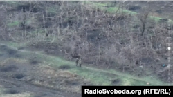 Військовий армії РФ прикривається беззбройною людиною у формі ЗСУ (скрін з відео, яке передали українські військові Радіо Свобода)