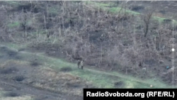 Российский военный, вероятно, прикрывается безоружным бойцом ВСУ перед украинскими позициями. 