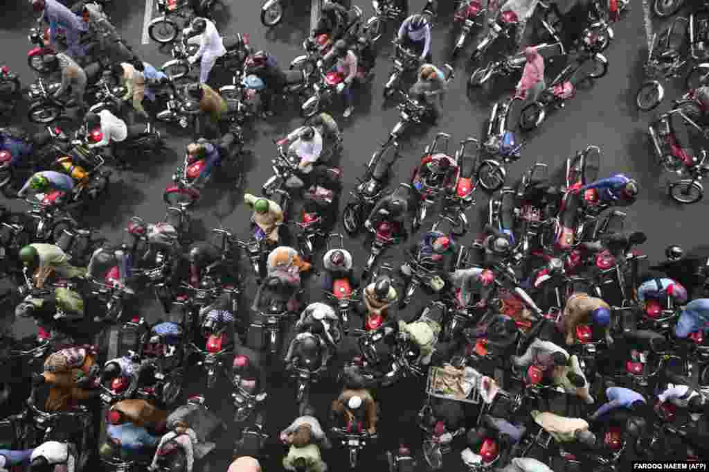 Commuters wait in traffic after other commuters blocked a road while sheltering under a bridge during a heavy rainfall in Islamabad.