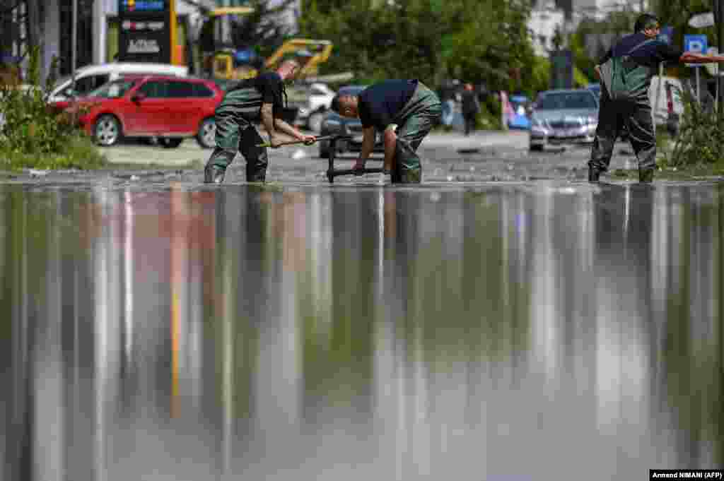 Workers unblock drains in Pristina after flooding in the Kosovar capital.&nbsp;