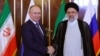 Ebrahim Raiszi iráni elnök (jobbra) üdvözli Vlagyimir Putyin orosz elnököt Teheránban 2022. július 19-én