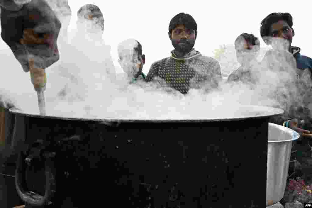 Indijska meteorološka služba izdala je upozorenje navodeći da će magle biti i narednih pet dana. na fotografiji: kupci čekaju da kupe slastice i koriste toplinu vatre kako bi se ugrijali, New Delhi, 26. decembra 2023.