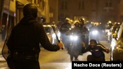 Нантер шаарындагы башаламандыкка чыккан жаран менен полиция кызматкерлери. 2-июлдун түнү, 2023-жыл. Франция.

